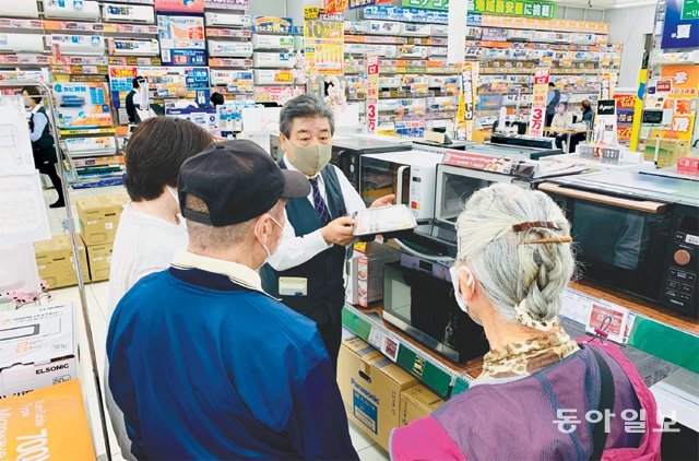 73세 판매 사원인 사토 다다시 씨(왼쪽에서 세 번째)가 가나가와현 후지사와시의 ‘노지마’ 가전 매장에서 고령의 고객들에게 전자레인지의 성능에 대해 설명하고 있다. 후지사와=김범석 특파원 bsism@donga.com