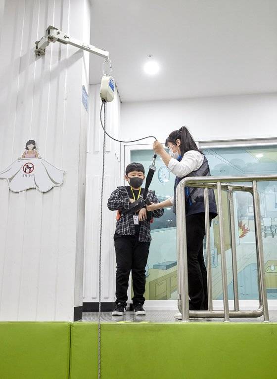 김지성 학생기자가 계단으로 대피할 수 없을 때 쓰는 피난 기구 완강기 사용법을 배우고 있다.