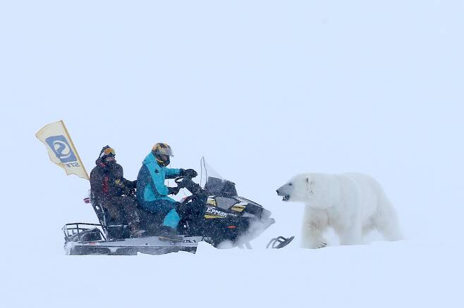 러시아 북극탐사대 연구자들이 알렉산드라 섬에서 스노우모빌을 타고 북극곰을 쫓고 있다. TASS=연합뉴스