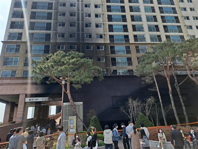 11일 경기 남양주시에 있는 지상 18층 규모의 주상복합건물이 전날 발생한 화재로 검게 그을린 모습. 건물 앞에 화재로 대피한 입주민들이 모여있다.