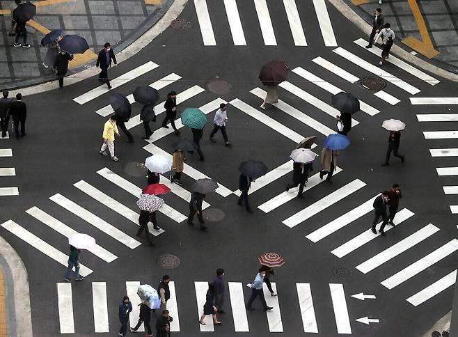 Pedestrians cross the street in downtown Seoul on Monday. (Yonhap News)