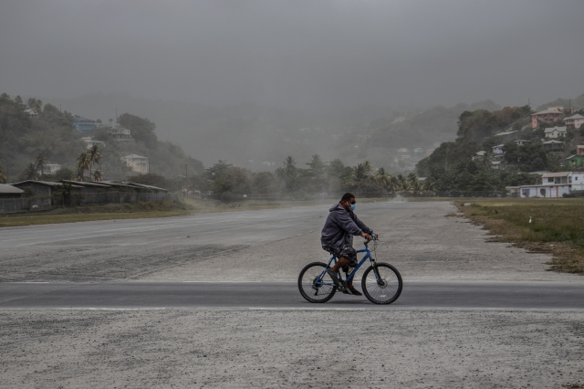 지난 11일 한 남성이 자전거를 타고 화산재로 뒤덮인 들판을 지나가고 있다. AP연합뉴스