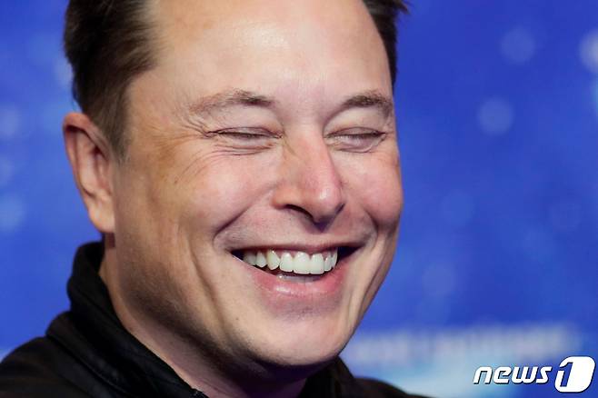SpaceX owner and Tesla CEO Elon Musk laughs after arriving on the red carpet for the Axel Springer award, in Berlin, Germany, December 1, 2020. REUTERS/Hannibal Hanschke/Pool
