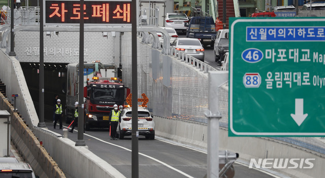 [서울=뉴시스]홍효식 기자 = 신월IC에서 여의도 구간을 연결하는 신월여의지하도로가 개통된 16일 서울 양천구 신월여의지하도로 진입구에서 대형화물차량이 진입하다 끼어 차로가 임시 폐쇄돼 견인차가 견인을 시도하고 있다. 2021.04.16. yesphoto@newsis.com