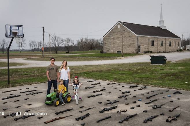 목사인 바렛과 그의 가족이 미국 인디애나주 포지빌의 교회 뒷마당에서 총기를 진열해 놓고 포즈를 취하고 있다. 사격 강사로도 일하고 있는 바렛의 소셜 미디어 계정은 많은 팔로워가 있다. 사진제공= World Press Photo