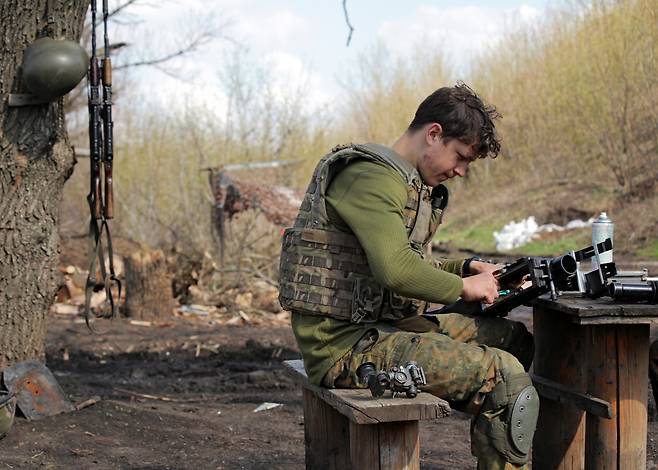 교전이 진행 중인 우크라이나 돈바스 지역에서 21일(현지시간) 우크라이나군 소속 군인이 장비를 점검하고 있다.[로이터]