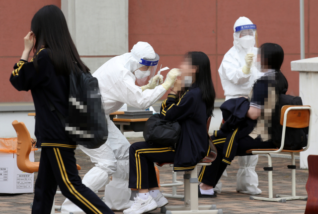 22일 오후 광주 북구 한 고등학교에 설치된 임시 선별진료소에서 학생들이 코로나19 검사를 받고 있다. 연합뉴스 제공