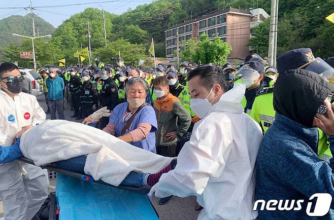 28일 오전 주한미군이 운용하는 경북 성주군 소재 고고도미시일방어체계(THAAD·사드) 기지 인근에서 경찰과 충돌 후 쓰러진 사드 반대 시민단체 회원이 들것에 실려 이송되고 있다. (사드 철회 소성리 종합상황실 제공) 2021.4.28/뉴스1