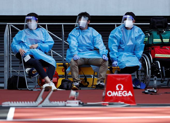 도쿄올림픽을 앞두고 도쿄국립경기장에서 열리고 있는 시범경기에서 의료진이 코로나19 감염 차단을 위해 개인방호복을 갖춰 입은 채 비상 대기하고 있다. [로이터]