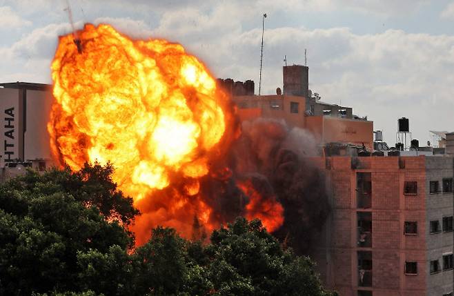 13일(현지시간) 이스라엘군의 공습을 맞은 팔레스타인 가자지구 한 건물에서 화염이 치솟고 있다(사진=AFP 연합뉴스).