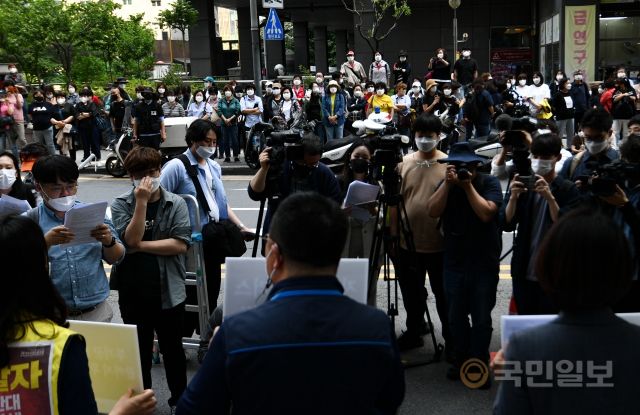 홈플러스 여성노동자들이 13일 서울 종로구 MBK파트너스 본사 앞에서 집단삭발 기자회견을 진행하고 있다. 길 건너 동료들이 기자회견을 바라보고 있다.