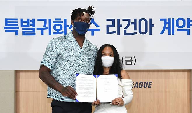 전주 KCC 라건아(왼쪽)가 14일 서울 논현동 KBL센터에서 특별귀화선수 계약서를 들고 부인과 함께 기념촬영을 하고 있다. KBL 제공