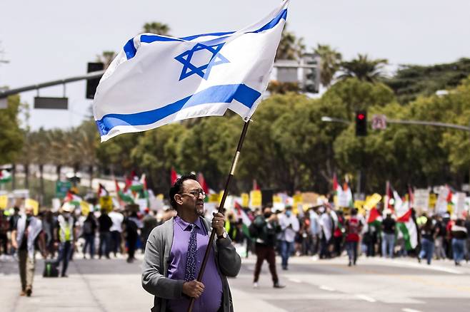 물론 모든 사람이 팔레스타인만 지지하는 것은 아니다. 15일 팔레스타인 지지 집회가 열린 미국 캘리포니아 LA의 이스라엘 영사관 근처에서 한 남성이 이스라엘 국기를 들고 있다. EPA=연합뉴스