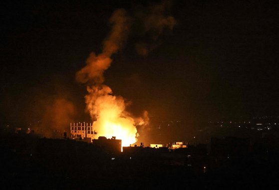 16일(현지시간) 새벽 팔레스타인 자치 지역인 가자지구 남부 라파 마을 상공에서 이스라엘군이 발사한 폭탄이 터지고 있다. [AFP=연합뉴스]