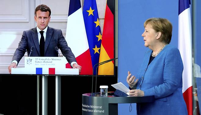 에마뉘엘 마크롱(왼쪽) 프랑스 대통령과 앙겔라 메르켈(오른쪽) 독일 총리가 31일(현지시간) 화상 정상회담을 하고 있다. [AP]