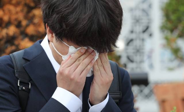 이준석 후보가 9일 국방부 앞에서 시위를 벌이고 있는 천안함 희생자 유가족과 대화를 나누다 눈물을 닦고 있다. 연합뉴스