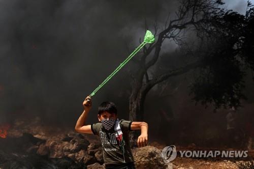 이스라엘군에 돌팔매질하는 팔레스타인 소년 [AFP=연합뉴스]
