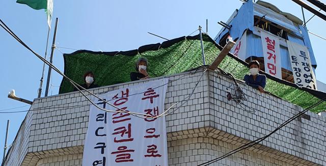 경기 구리시 인창C구역에 있는 여관 '성일장' 옥상에 있는 이해옥(가운데)씨와 김경석(맨 오른쪽) 김수연씨. 이들은 철거에 반대해 이달 1일부터 옥상에서 농성을 벌이고 있다. 전혼잎 기자