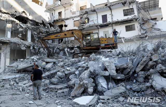 15일(현지시간) 가자지구 내 가자시티에서 이스라엘 공습으로 파괴된 건물 잔해 제거 작업이 진행되고 있다. 이 건물은 지난달 이스라엘과 하마스 간 11일간의 무력 충돌 중 파손됐다. /AP=뉴시스