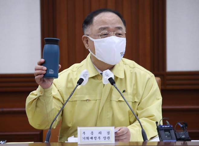 <YONHAP PHOTO-3535> 텀블러 사용 권유하는 홍남기 부총리 (서울=연합뉴스) 김승두 기자 = 홍남기 경제부총리 겸 기획재정부 장관이 18일 정부서울청사에서 열린 제38차 비상경제 중앙대책본부 회의 겸 2021년 제4차 혁신성장전략회의에 참석해 장관들에게 텀블러를 나누어주고 사용을 권유하고 있다. 2021.6.18 srbaek@yna.co.kr/2021-06-18 10:40:13/ <저작권자 ⓒ 1980-2021 ㈜연합뉴스. 무단 전재 재배포 금지.>