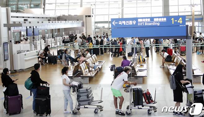 (인천공항=뉴스1) 권현진 기자 = 여행객들이 11일 오후 인천국제공항 제1터미널에서 출국하기 위해 줄을 서 있다. 정부는 코로나19 백신 접종 완료자에 한해 이르면 7월부터 싱가포르와 괌, 사이판 등 단체 해외여행을 허용하는 여행안전권역(트래블 버블)을 추진한다고 밝혔다. 2021.6.11/뉴스1