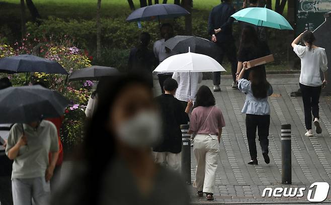 게릴라성 폭우가 내린 지난달 30일 서울 여의도환승센터에서 시민들이 점심식사를 위해 걸음을 재촉하고 있다. /사진=뉴스1