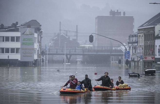 서유럽에 내린 폭우의 영향으로 강물이 제방을 타고 범람한 벨기에 리에주의 침수 지역에서 15일(현지시간) 주민들이 고무보트를 타고 이동하고 있다.   AP|연합뉴스