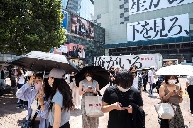 7월 12일 도쿄 도심 거리에 마스크를 쓴 시민들이 걸어가고 있다./AFP 연합뉴스
