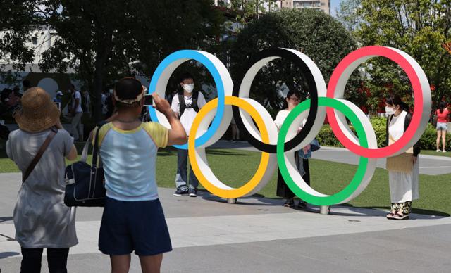 22일 시민들이 개막식이 열릴 도쿄올림픽스타디움 앞 오륜기 조형물에서 기념촬영을 하고 있다. 도쿄=올림픽사진공동취재단