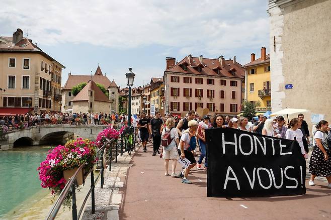 프랑스 동부 아네시 시민이 24일 "부끄러운 줄 알라"고 쓴 플래카드를 들고 행진하고 있다. AFP=연합뉴스