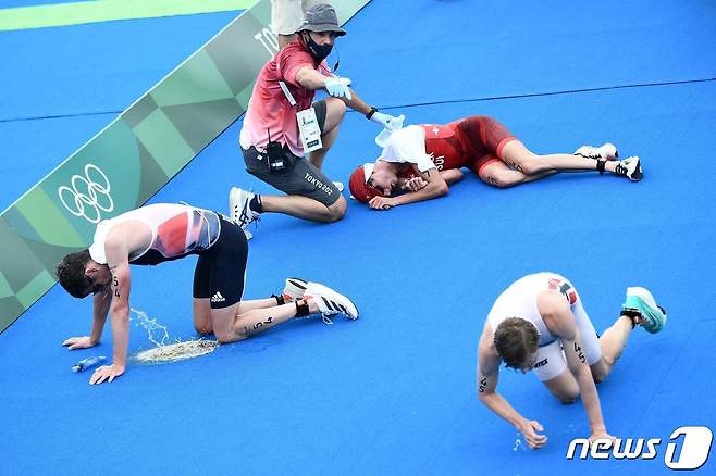 26일 도쿄 오다이바 해상공원서 열린 트라이애슬론 경기 후 선수들이 고통을 호소하고 있다.© AFP=뉴스1 © News1 이동원 기자