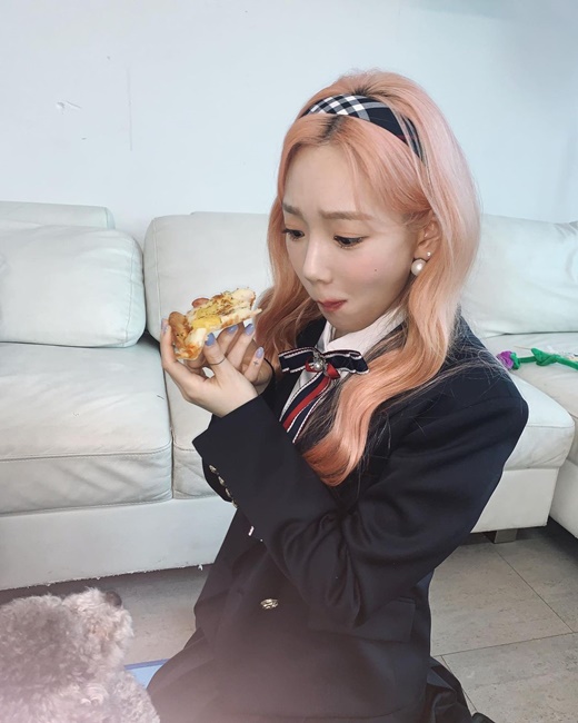 Group Girls Generation member Taeyeon perfected Sukluk.Taeyeon posted several photos on his 28th day with the message Eat Pizza and cheer hard.In the open photo, Taeyeon is staring at the camera with a smile holding a pizza, with white skin and pink hair highlighting his innocence.A youthful styling like uniform is also noticeable: dressed in a black two-piece, he added a cute charm with a ribbon tie and a check headband.The debut and the unchanging fresh beautiful look are admiring.In the ensuing photo, the dog Xero, who looks at Taeyeon eating Pizza, looks like a laughing dog.The two cute faces made the viewers smile.The netizens who watched the photos commented on It is so cute!, Xero , Pizza is the most cute person in the world and so on.Meanwhile, Taeyeon released a new song Weekend on the 6th.