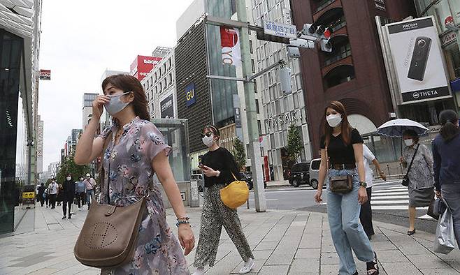 일본 도쿄 시내에서 26일 신종 코로나바이러스 감염증(코로나19) 예방 마스크를 쓴 시민들이 길을 걷고 있다. 도쿄=AP연합뉴스