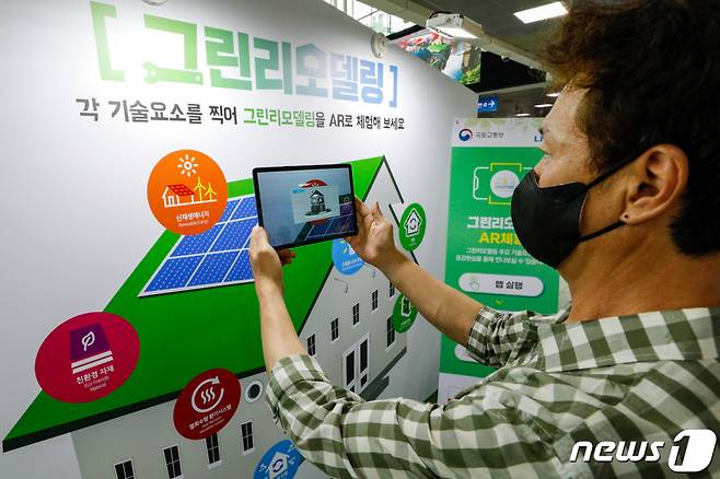 (서울=뉴스1) 안은나 기자 = 5일 중구 KTX 서울역에 마련된 그린리모델링 팝업하우스에서 시민이 AR체험을 하고 있다. 국토교통부와 LH는 건물 에너지 성능을 향상시키고 쾌적한 실내 환경을 조성하는 그린리모델링의 효과에 대한 대국민 인지도와 이해도를 높이기 위해 그린리모델링 팝업하우스를 오픈했다. 그린리모델링 전후 변화를 체감하는 반반하우스 전시, 그린리모델링 갤러리존, AR(증강현실) 체험존, 이벤트존, 포토존으로 구성됐으며 오는 31일까지 열린다. 2021.7.5/뉴스1