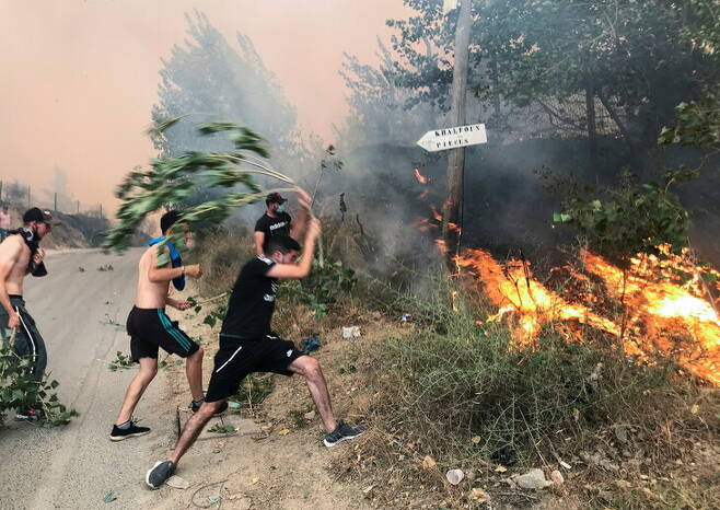 지중해 연안국들이 폭염과 산불에 시달리고 있는 가운데 알제리 북부 지역 티지우주에서 10일(현지시각) 청소년들이 맨몸으로 산불을 끄고 있다. 티지우주/로이터 연합뉴스