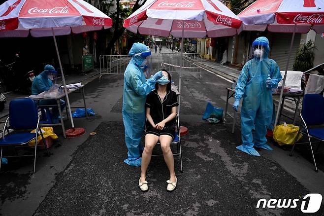 (하노이 AFP=뉴스1) 우동명 기자 = 11일 (현지시간) 베트남 하노이에서 주민이 코로나19 면봉 검사를 받고 있다.   (C) AFP=뉴스1