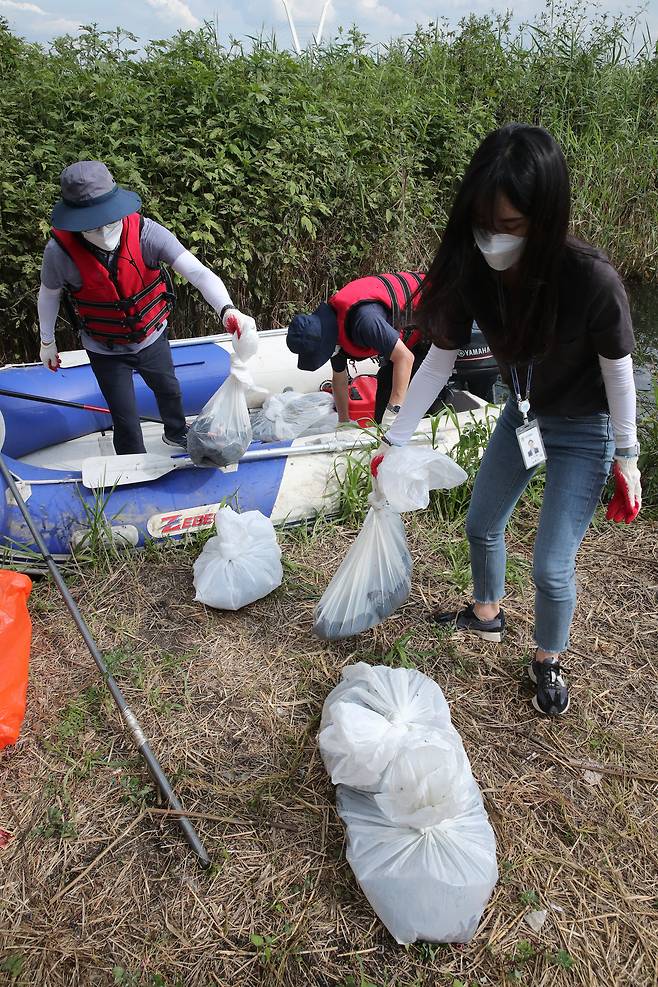 이날 작업을 마친 관계자들이 두시간 여동안 수거한 폐사체들을 보트에서 내리고 있다. 저어새는 없었고, 폐사한 잉어와 갈매기 등이 수거됐다. 우상조 기자