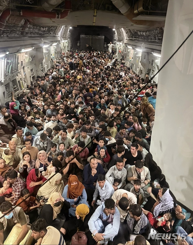 [AP/뉴시스] 탈레반이 아프간 수도 카불 도심에 무혈 입성한 15일 밤 민항기 운항이 중단된 카불 하미드카르자이 국제공항에 탈레반 치하의 아프간을 탈주하려는 사람들이 공항으로 몰려와 마침 문이 열려진 미군 C-17 수송기 안으로 무작정 진입해 자리를 잡았다. 수송대상도 아니고 보안검사를 거치지 않은 민간인들이 대부분이었고 탑승인원이 수용한도를 넘어서는 640명에 달했다. 수송기 조종사들은 이들을 내리게 강제하는 대신 그대로 싣고 카타르 미군기지까지 날아갔다. 미공군 제공 사진. 2021. 8. 18.