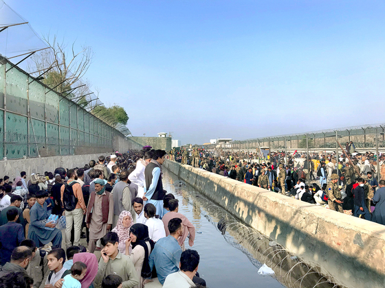 지난 22일(현지시간) 아프가니스탄 카불의 카불국제공항 입구 인근에 사람들이 몰려들고 있다. 신화=연합뉴스