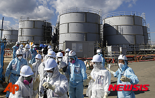 [오쿠마=AP/뉴시스] 사진은 지난 2월 10일 보호복을 입은 기자들이 후쿠시마현 오쿠마에 있는 도쿄전력 원전의 방사성 물질 오염수 저장시설을 살펴보는 모습. 8일 지지통신은 후쿠시마 제1원전에서는 지금도 매일 400t가량의 오염수가 증가하고 있다고 보도했다. 2016.03.08