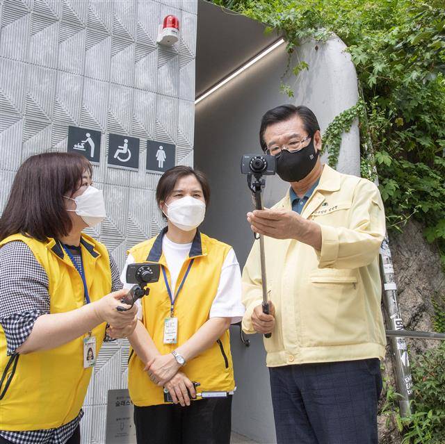 성장현(오른쪽) 용산구청장이 이태원 공중화장실 앞에서 시민감시단과 함께 불법촬영 카메라 탐지기를 살펴보고 있다.용산구 제공