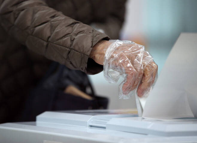 일회용 장갑을 낀 유권자가 투표함에 투표지를 넣고 있다. 연합뉴스