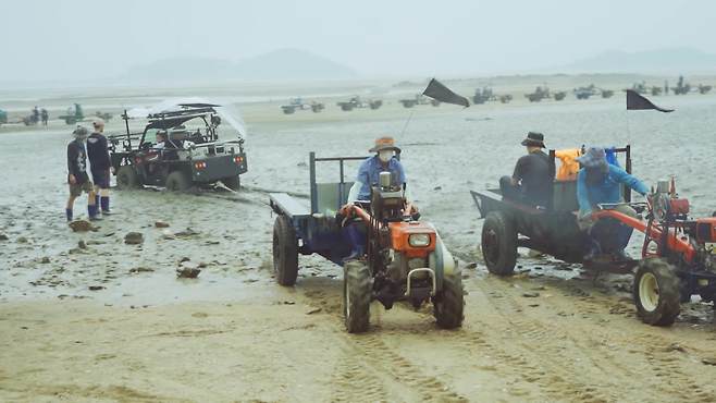 갯벌에 빠진 촬영용 차량을 주민들이 꺼내주는 모습