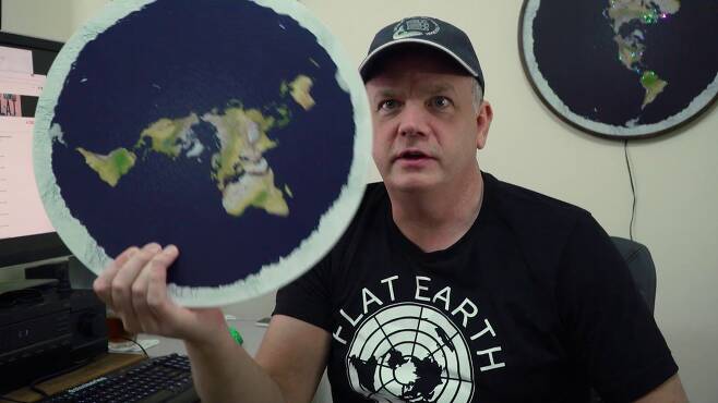 '평면 지구인들의 왕'으로 불리는 마크 서전트가 평평한 지구 모형을 들고 있는 모습. /넷플릭스