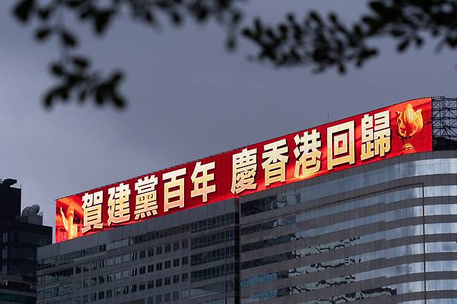 2021년 6월 29일 홍콩 시내 한 건물 외벽의 대형 LED 전광판에 중국 공산당 창당 100주년과 홍콩 주권반환 24주년을 축하하는 문구가 나오고 있다. /연합뉴스