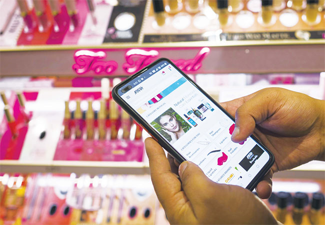 한 고객이 휴대전화로 인도 화장품 업체 나이카(Nykaa) 앱에 접속, 제품을 검색하고 있다. 사진 블룸버그