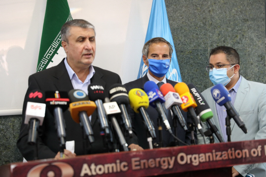 라파엘 그로시(가운데) 국제원자력기구(IAEA) 사무총장과 모하마드 에슬라미(왼쪽) 이란 원자력청장이 12일 이란 테헤란에서 열린 기자회견에서 이란 핵 시설에 대한 제한된 사찰 합의 사실을 발표하고 있다. EPA 연합뉴스