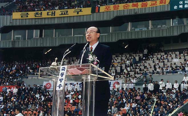 David Yong-gi Cho delivering a sermon to an outdoor gathering (The Hankyoreh)