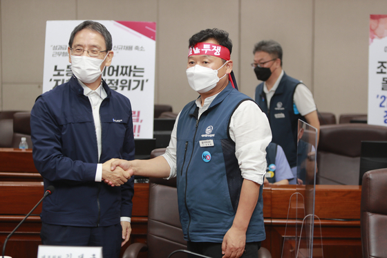 Members from Seoul Metro and the Seoul Transit Corporation Labor Union shake hands after reaching a last-minute agreement at the Seoul Metro Headquarters in Seongdong District, eastern Seoul, shortly before midnight on Monday. Accordingly, a strike by Seoul subway workers scheduled for Tuesday was called off. [NEWS1]