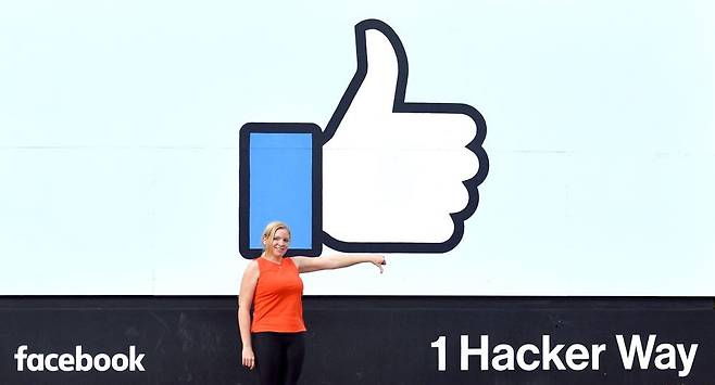 지난 2018년 미국 캘리포니아주 멘로파크에 있는 페이스북 본사 앞에서 한 여성이 엄지손가락을 아래로 내리는 포즈를 취하고 있다. /사진=AFP통신